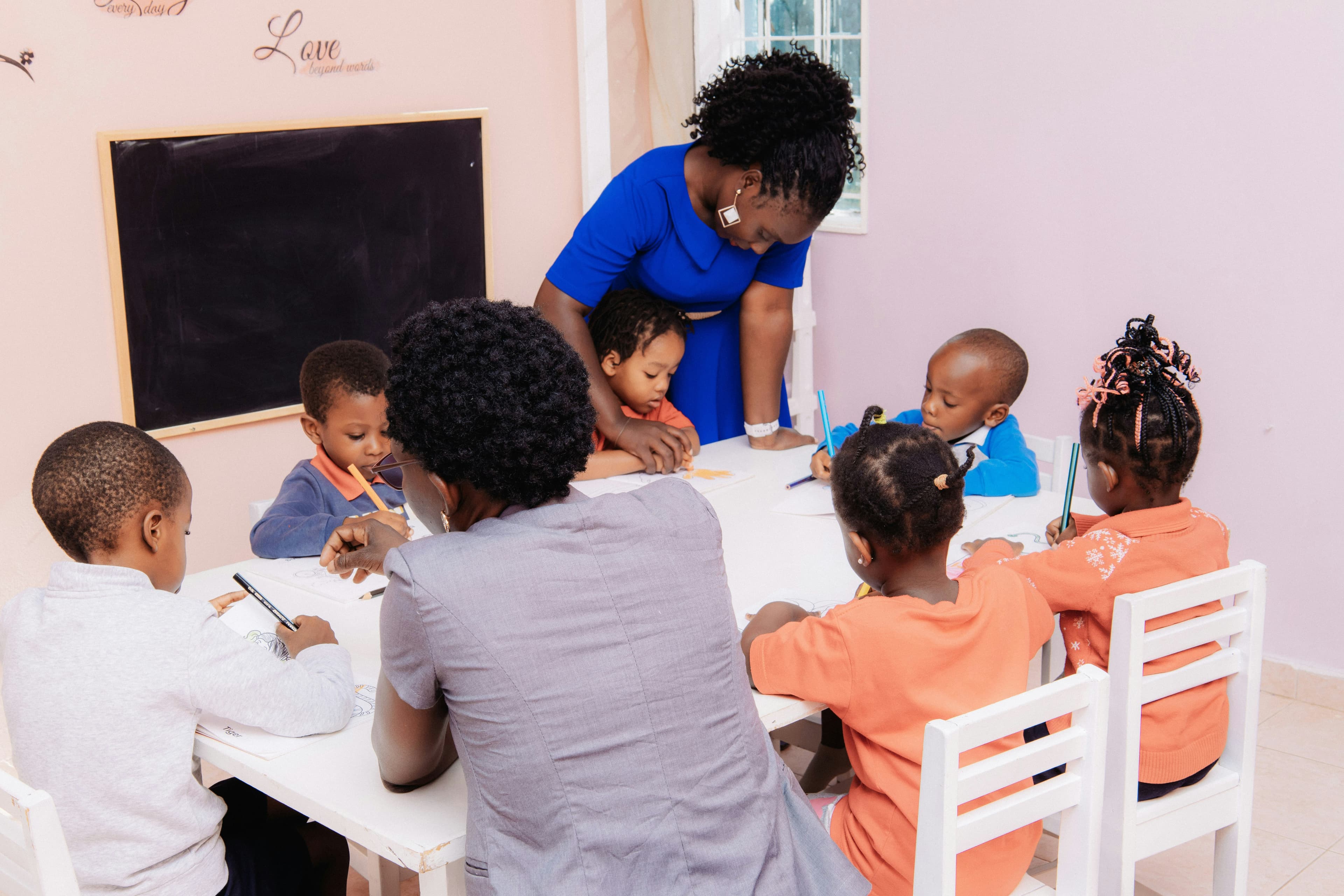 A teacher guiding students around a classroom table