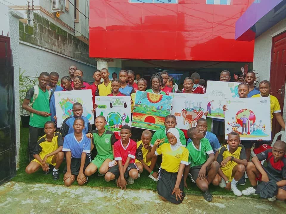 Students in colourful sports uniforms presenting their environmental art posters